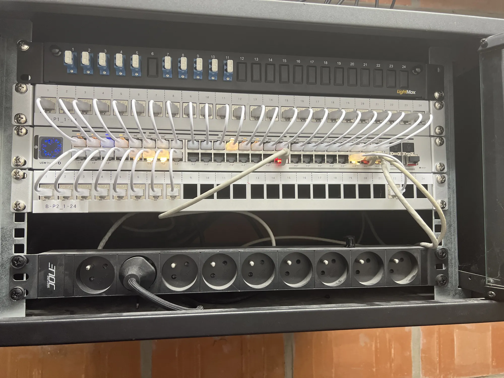 Netwerkpatchpanelen en stroomverdeling in een AAQUA-wandkast