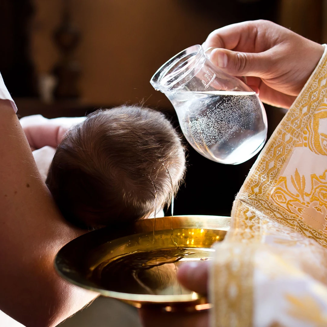 A priest preparing the holy water for a baptism