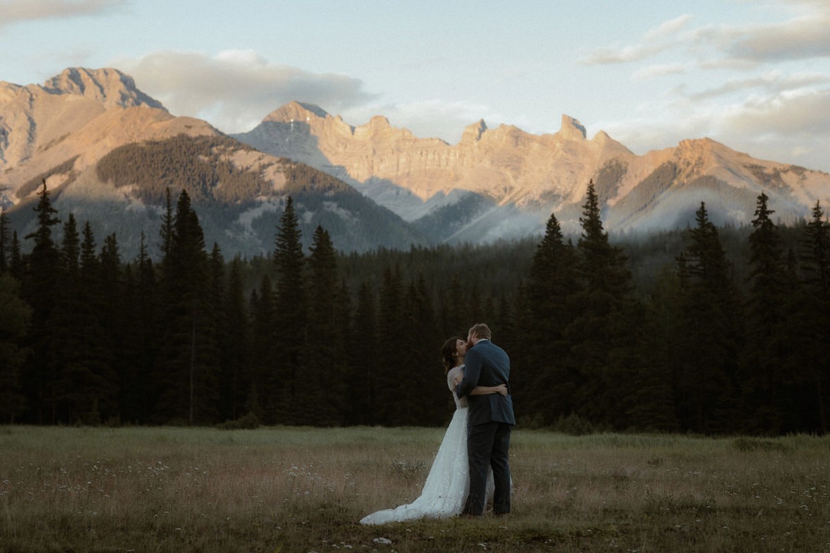 Wedding Couple kissing with mountain range backdrop