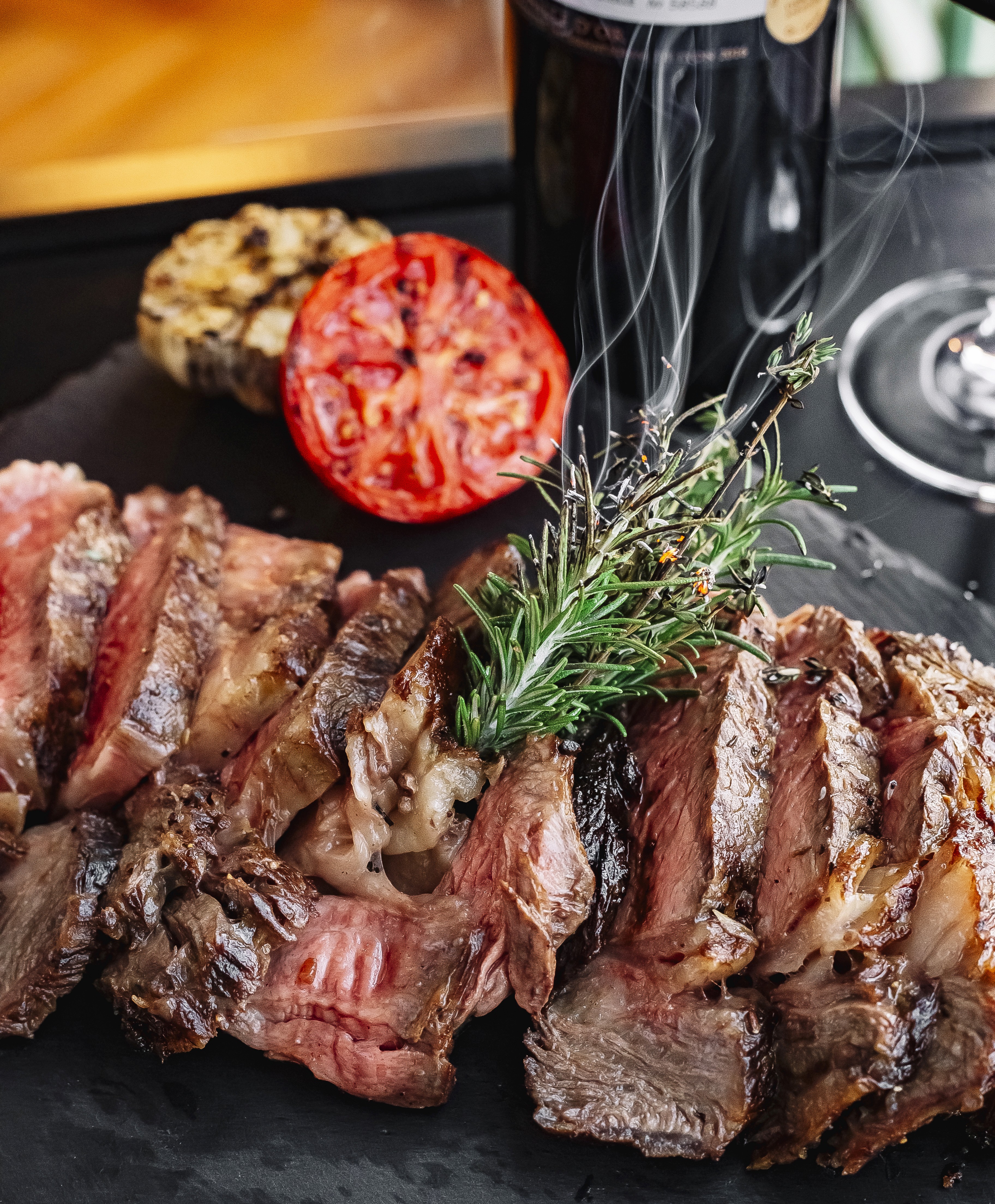 A hand lifting the first slice of a pizza on a marble table