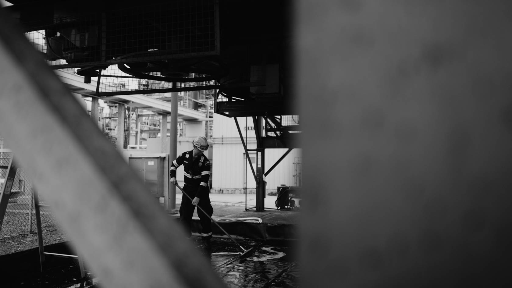 Hand in lace sleeve holding a lit white candle against a red background, wearing a silver ring with a dark gemstone.