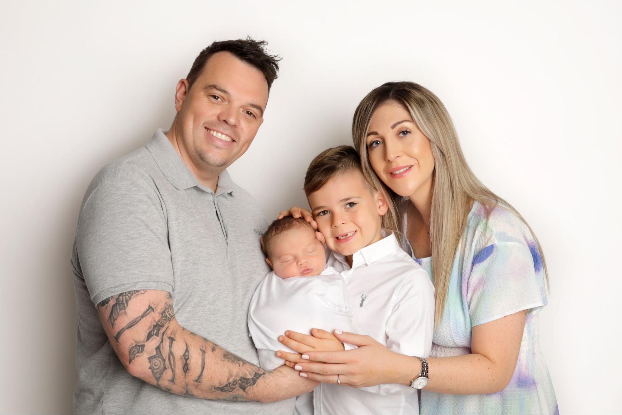 A warm and happy family photoshoot with their newborn baby, capturing pure joy at Mahvin Photography in Dubai, UAE.