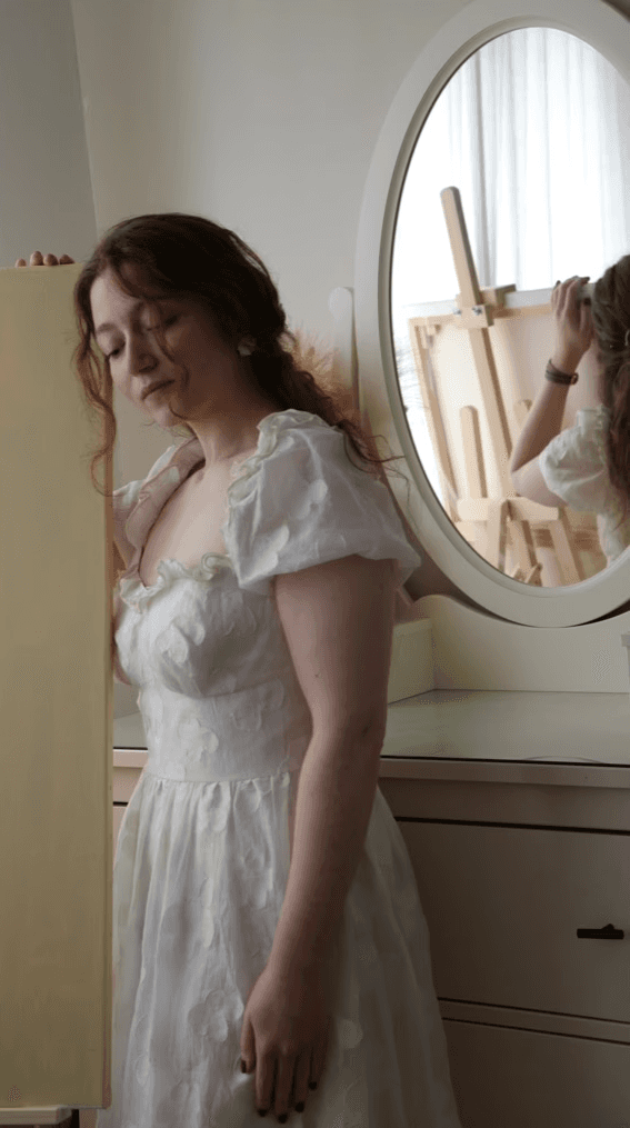 femme a côté de sa toile