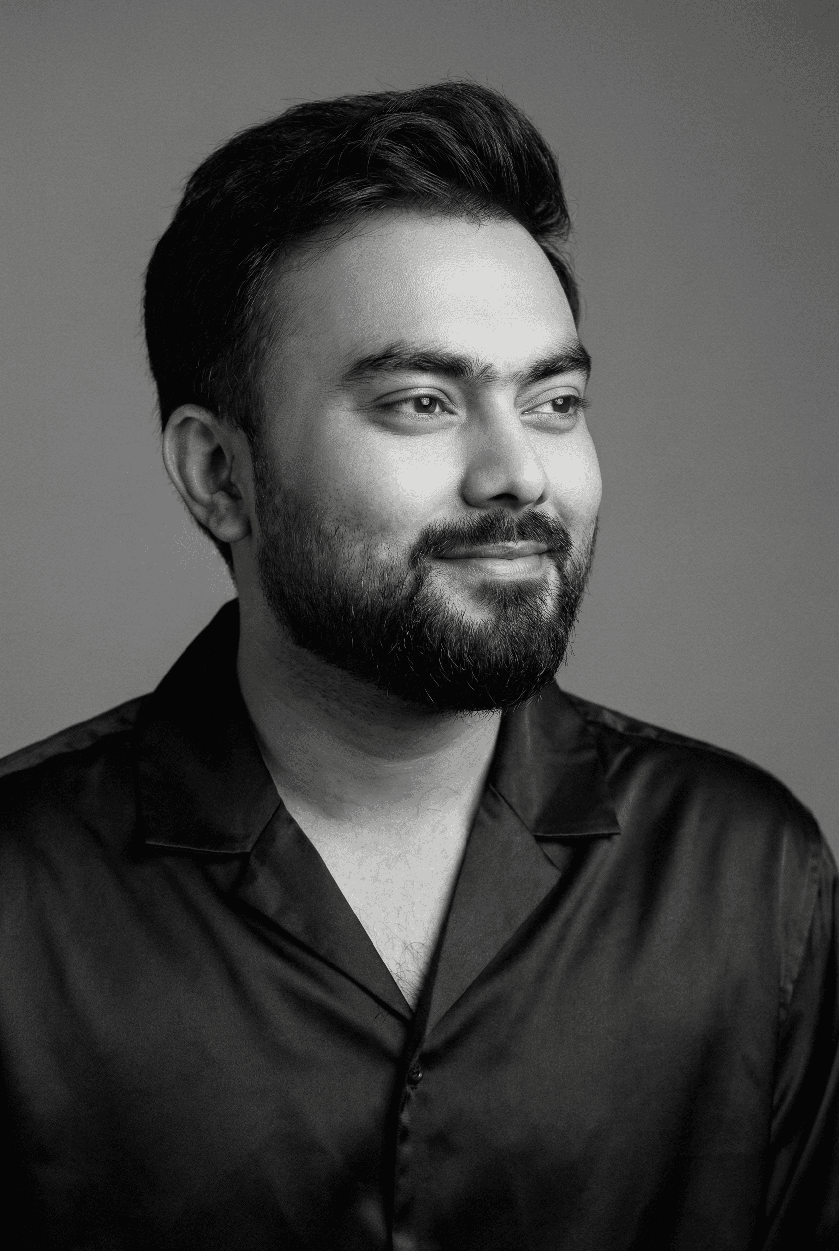 Portrait of a woman with straight long hair, in a dark t-shirt, set against a neutral backdrop.
