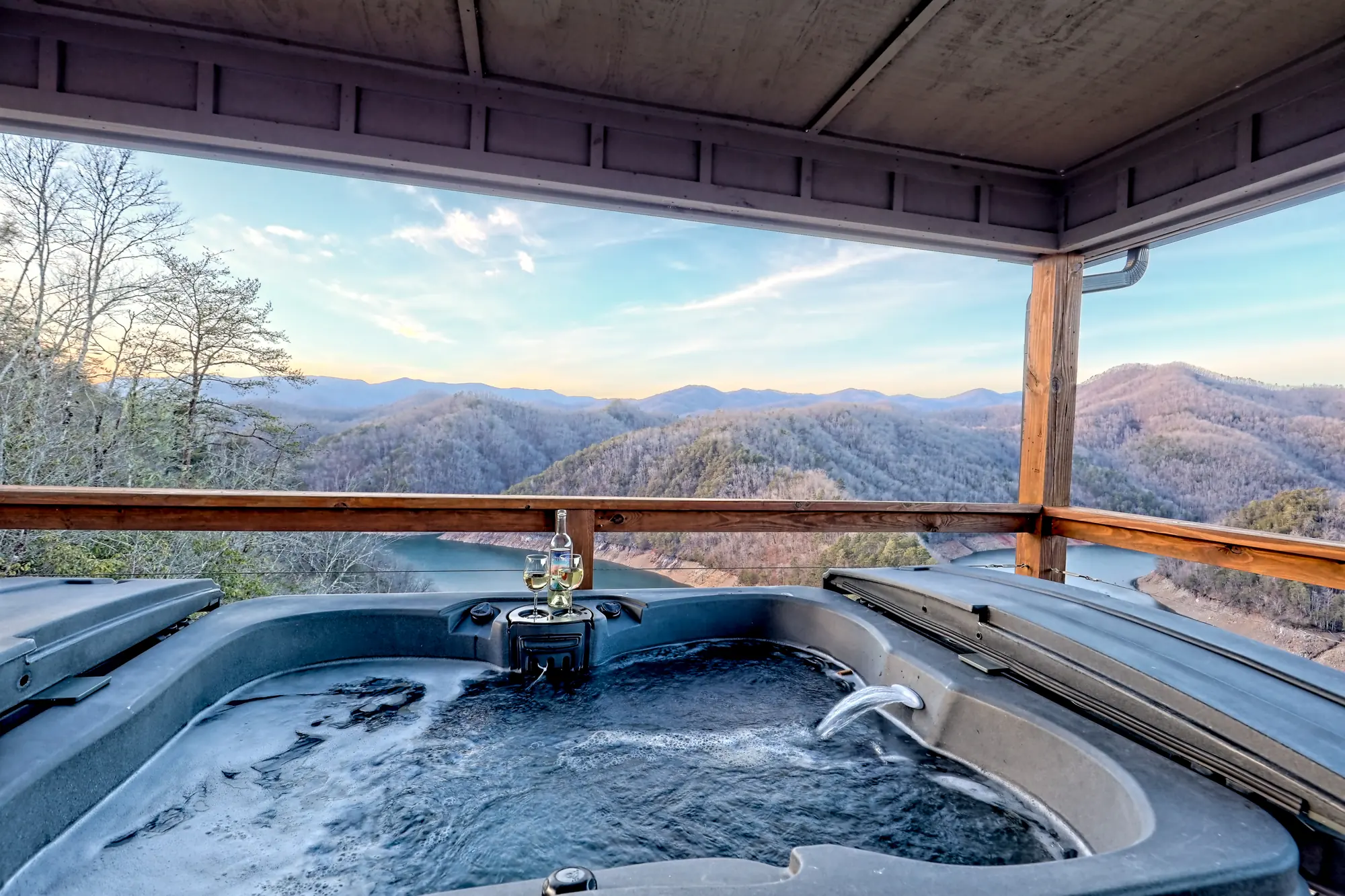Eagles Landing hot tub under a covered deck at sunset over the mountains