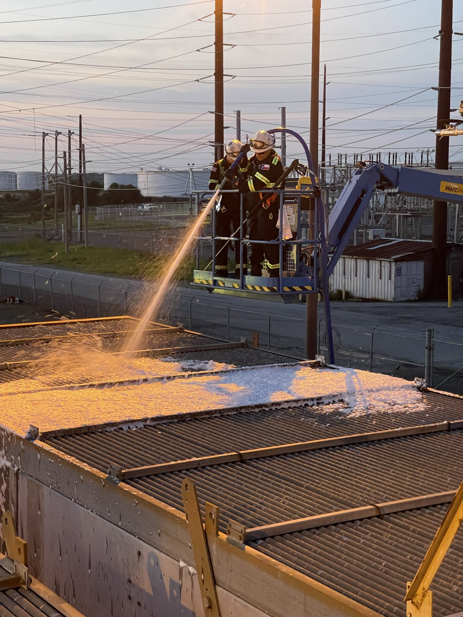 frontline workers spraying chemicals on industrial equipment for cleaning
