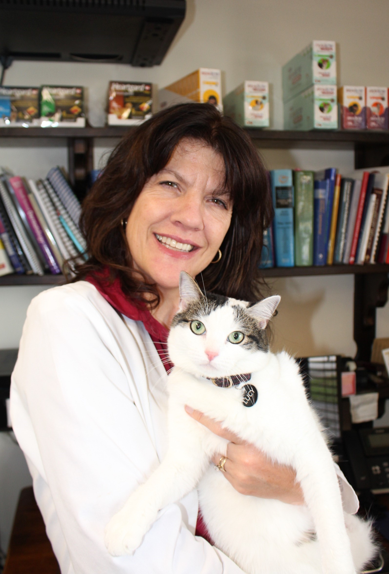 dr.formoso holding lucy the cat in front of shelves