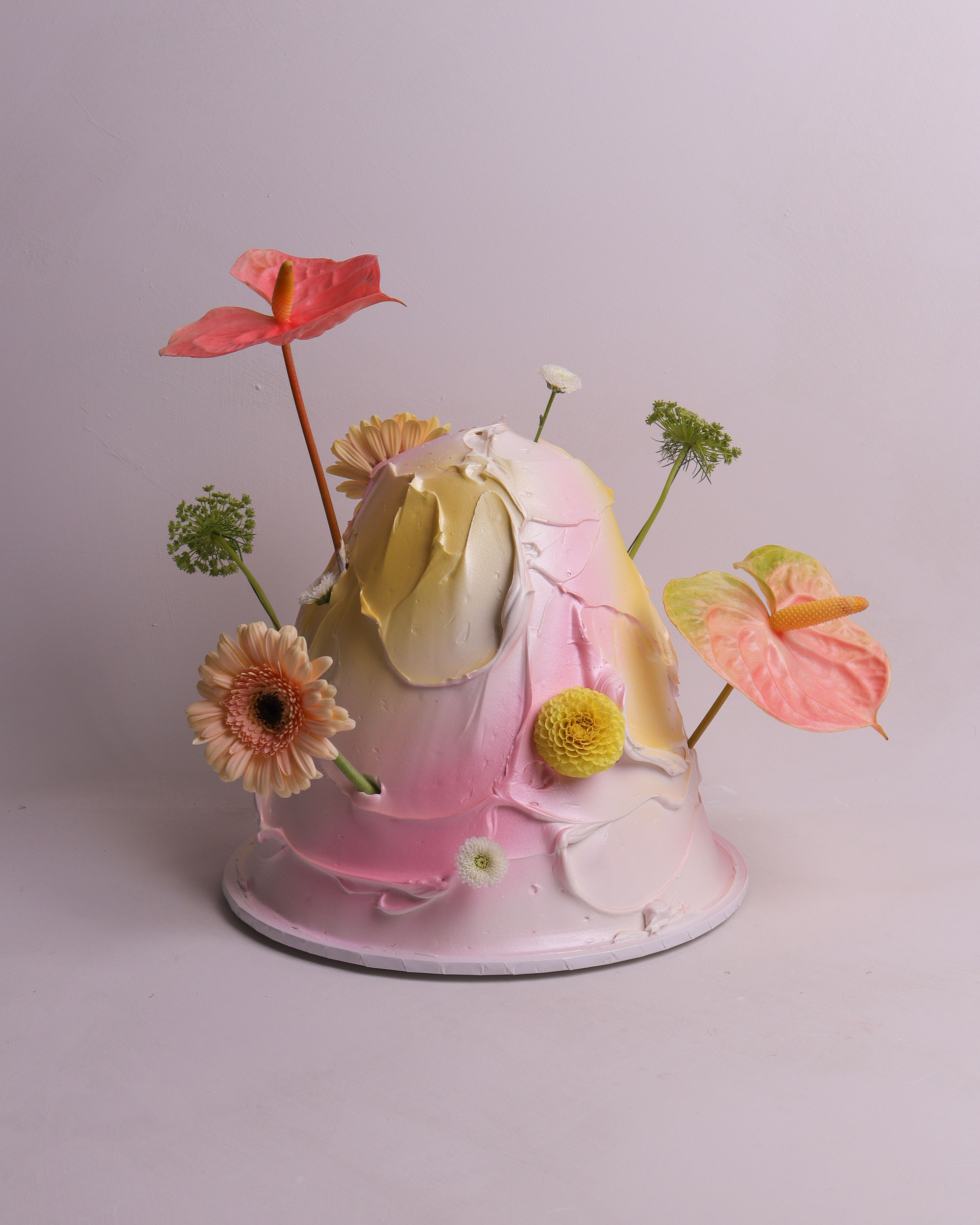 Pink two tier wedding cake with piped buttercream swags, ruffled borders and ribbon detailing in a romantic vintage style