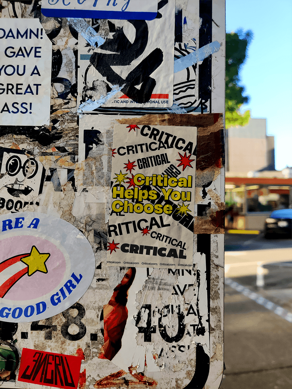 A sticker on a post saying "Critical helps you choose"
