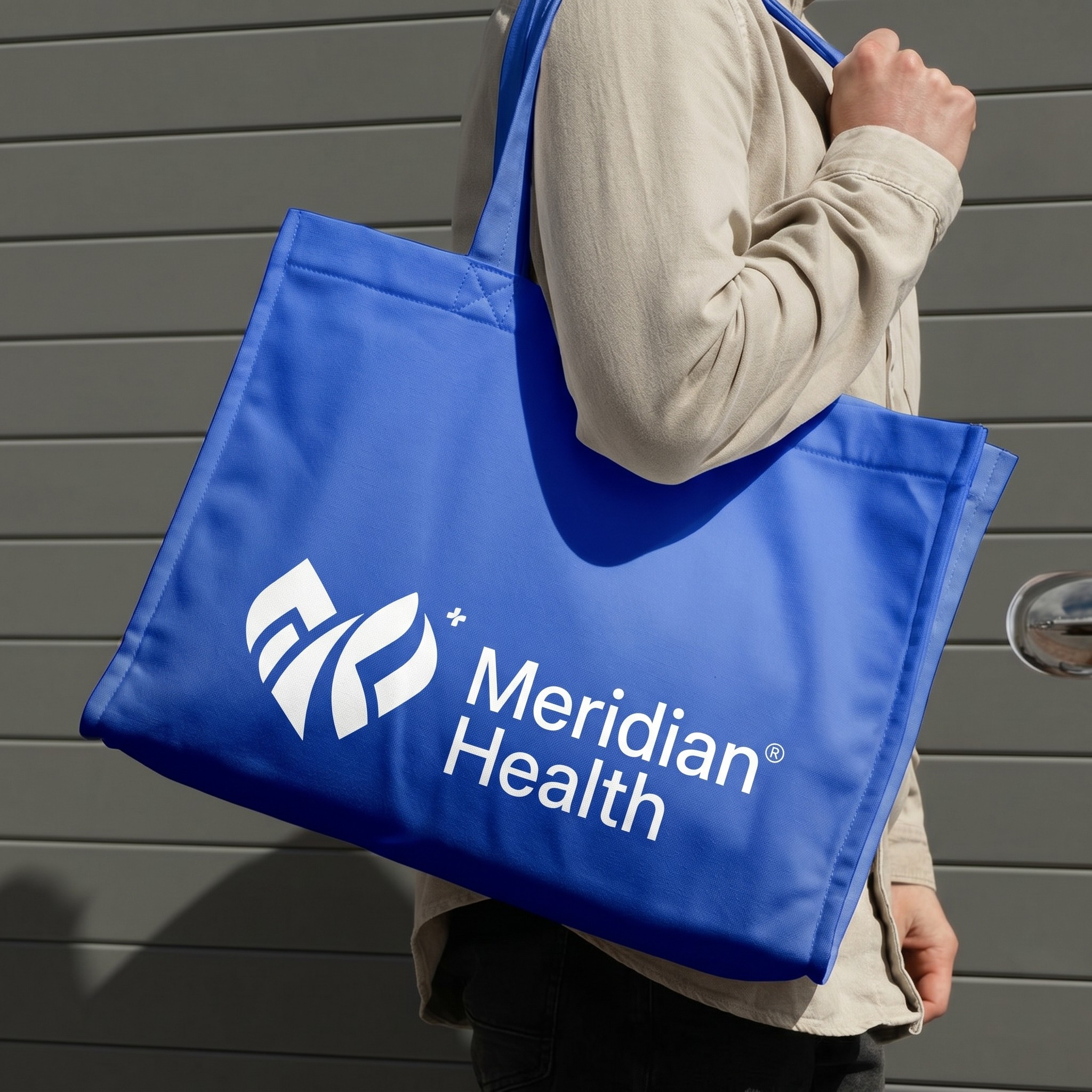 meridian health logo on a tote bag ina womans hand