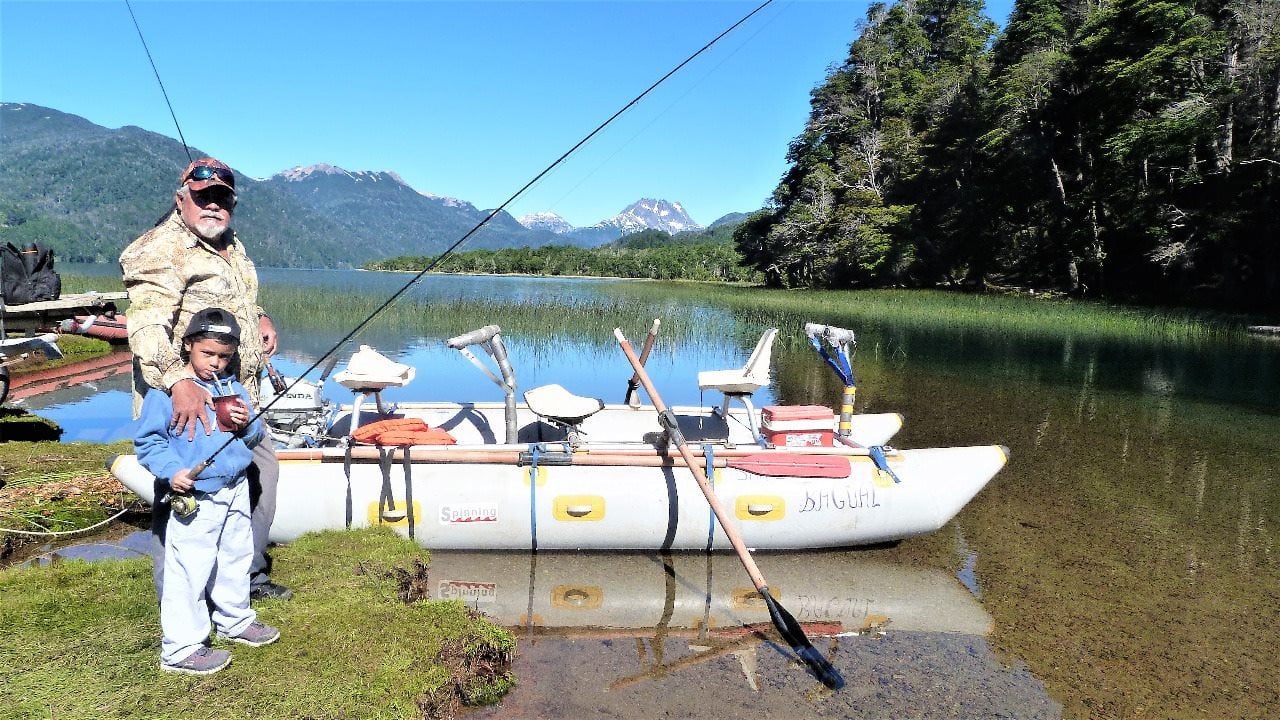 Eduardo con un niño a punto de embarcar , en la orilla del río