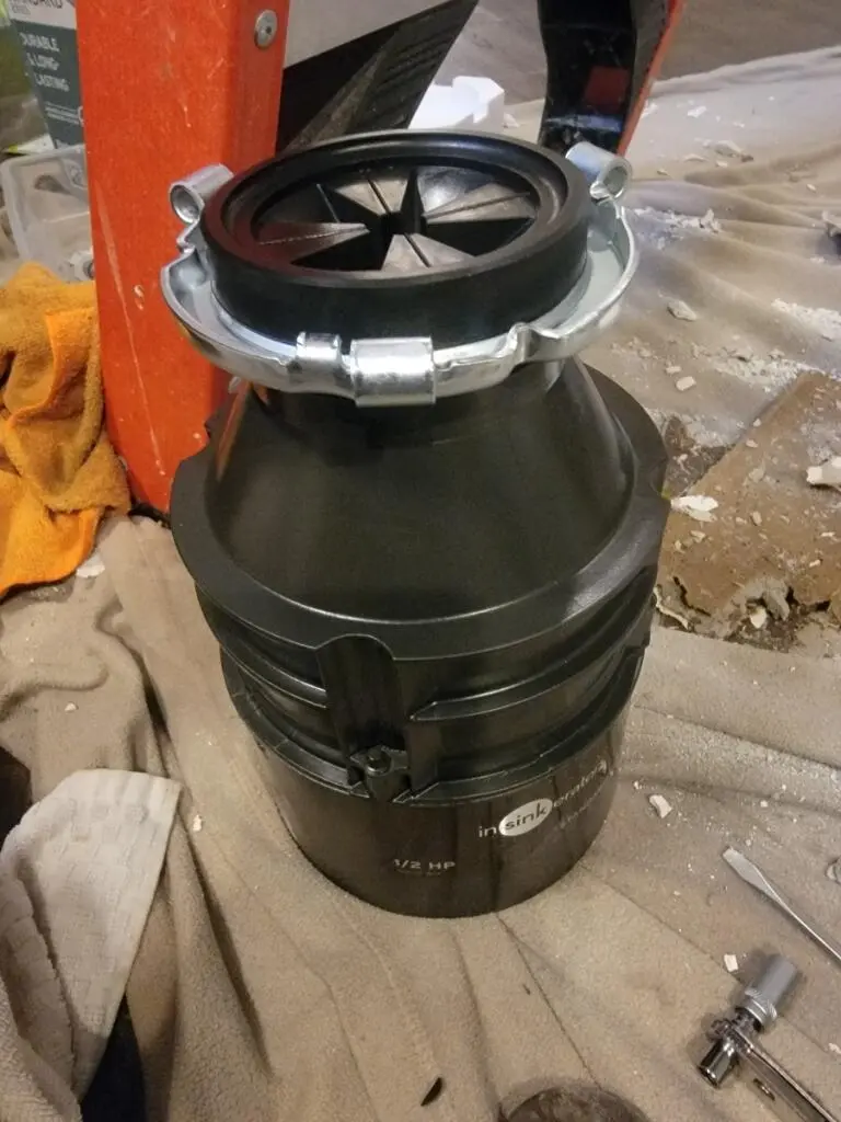 A new 1/2 HP InSinkErator garbage disposal unit prepared on a drop cloth for a professional garbage disposal installation.