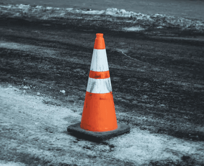 A traffic cone on a winter road symbolizing truck accident