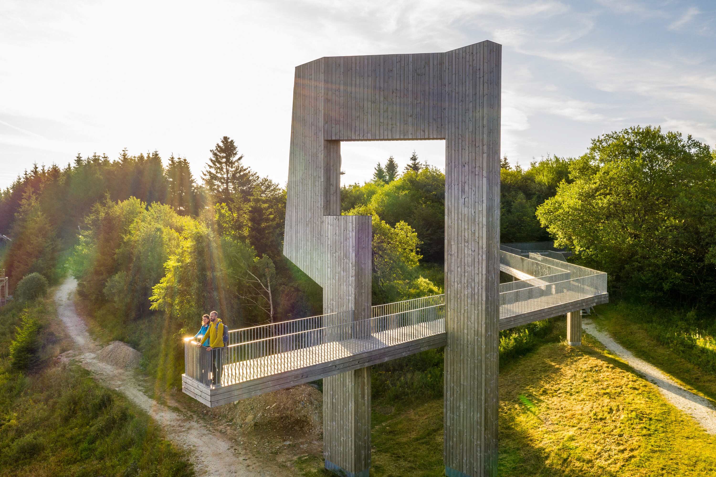 Wanderer auf Windklang auf dem Erbeskopf im Hunsrück Die durchschreitbare Skulptur Windklang auf dem Erbeskopf ermöglicht eine gute Aussicht über den Hunsrück. Wie der Name bereits vermuten lässt, kann man abhängig von der Wetterlage verschiedene Klänge dieser aus Holz und Metall bestehenden Plattform wahrnehmen.