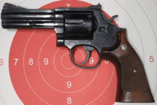 Revolver Smith & Wesson .357 Magnum in acciaio inossidabile con impugnatura ergonomica e canna media, fotografato su sfondo neutro