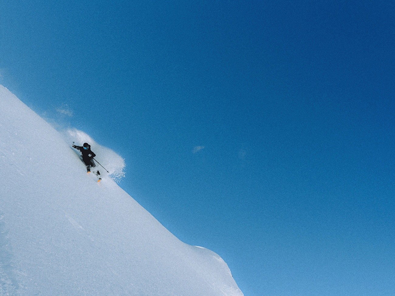 Skier descending a steep alpine powder slope during a Snow Labs training session by weAltura Academy in a high-mountain winter environment.