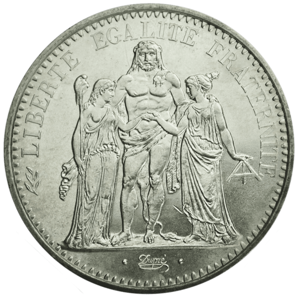 A smiling young man with crossed arms, wearing a plaid shirt and white t-shirt, poses against a dark background.