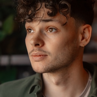 Business professional profile portrait: a man in a green shirt looking off into the distance