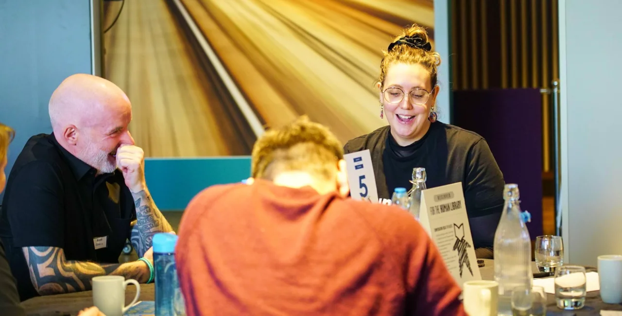 Three participants smiling and talking at a Human Library event in Prague.