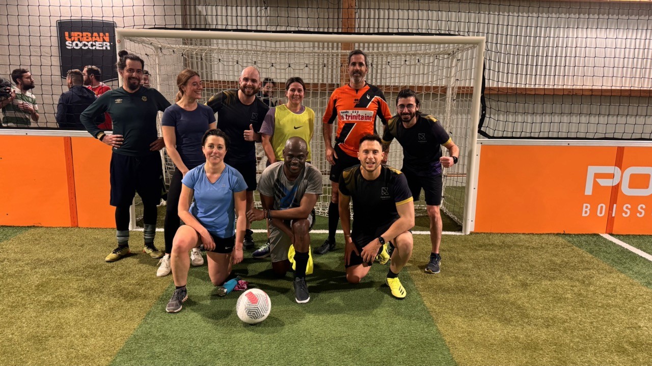 équipe de foot qui pose devant une cage de but