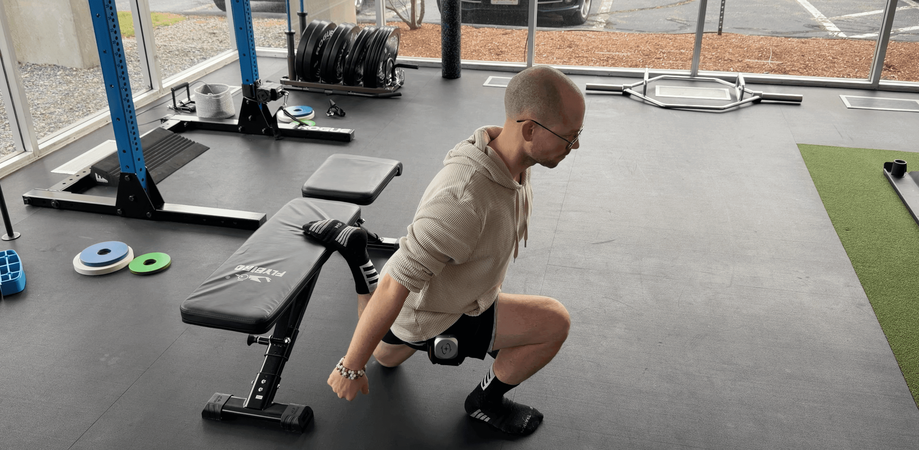 man performing DB bulgarian split squat with BFR cuff on
