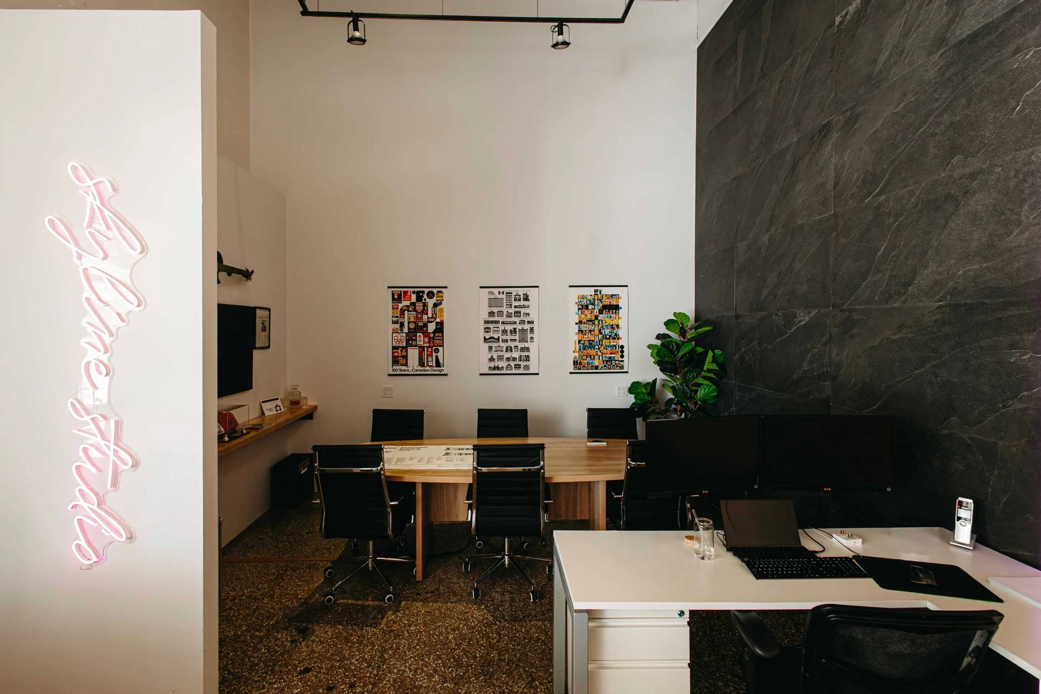 A closeup of the Skyline Boardroom with a neon sign visible alongisde a custom tile feature wall on the right