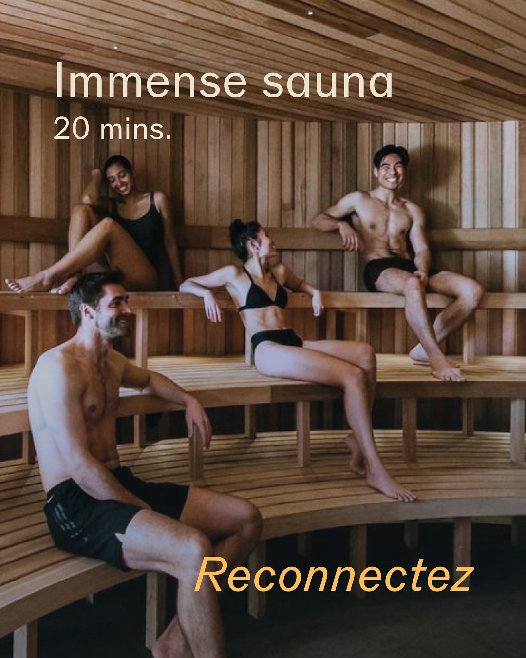 Four people relax in a spacious wooden sauna, seated on curved benches and wearing swimwear.