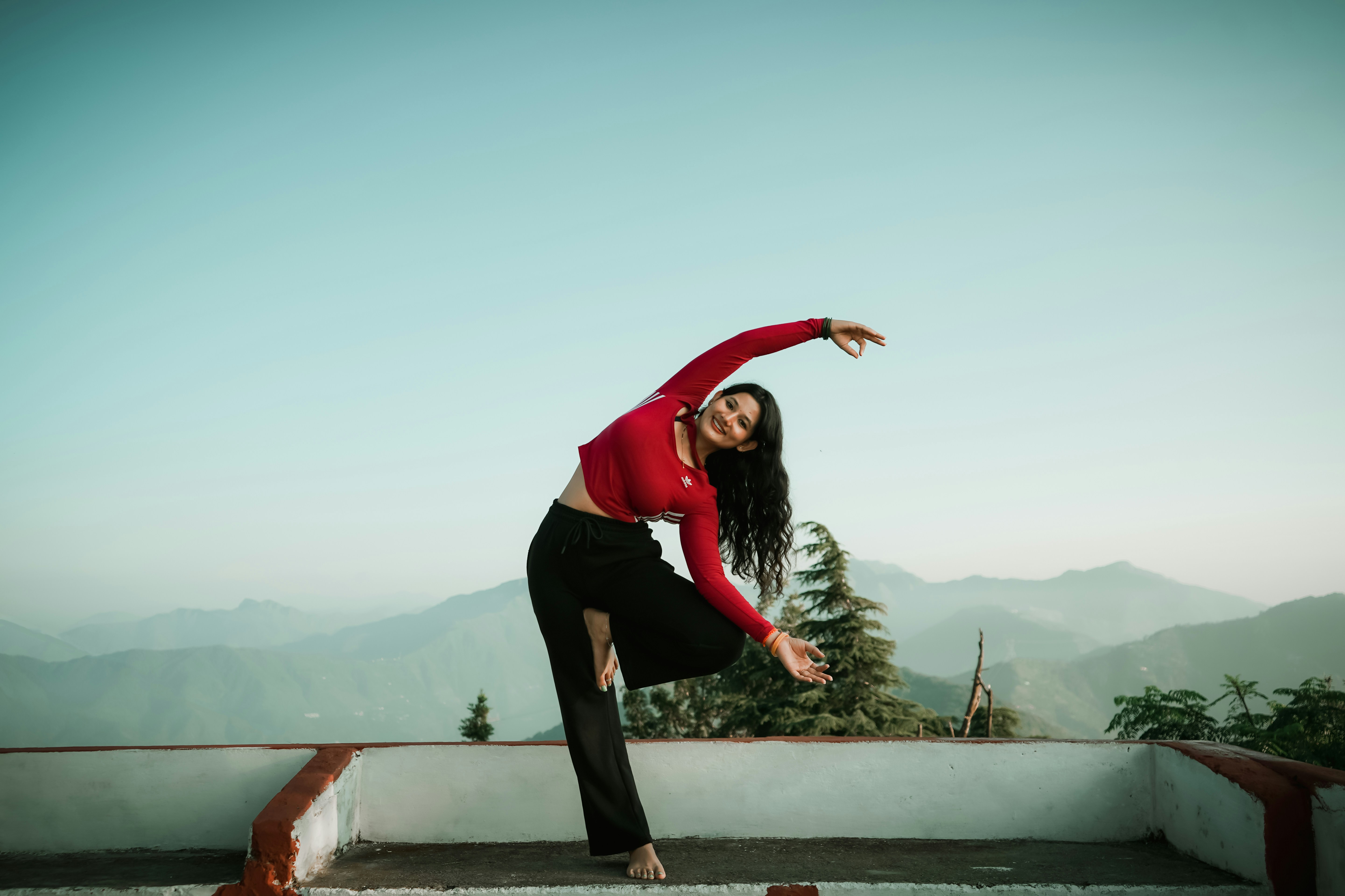 A woman in a red shirt is doing a trick