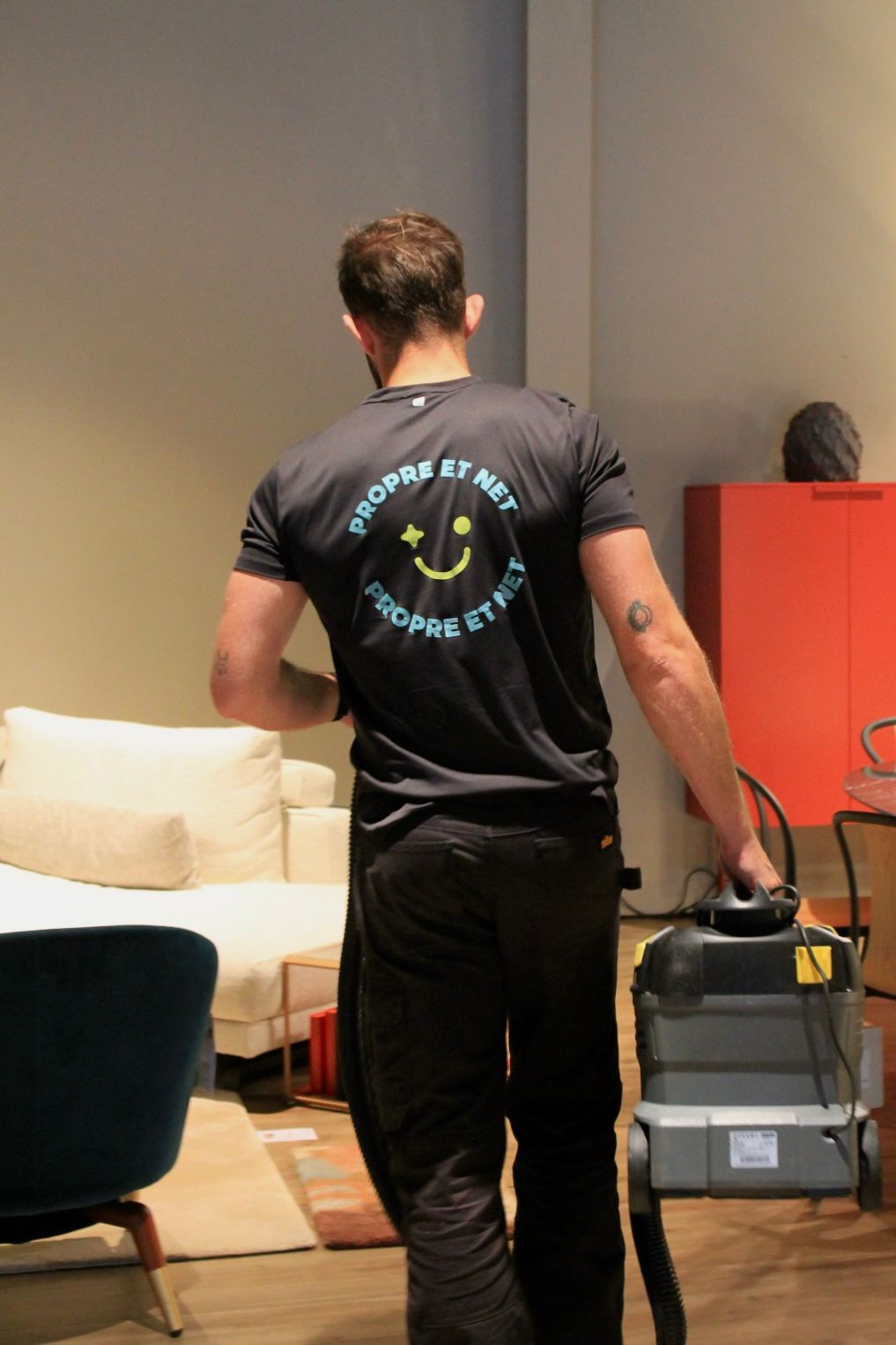 Technicien en tenue Propre et Net en train de nettoyer en profondeur un canapé