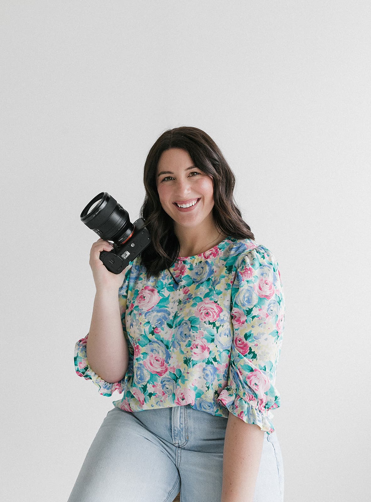 Carly Butts holding a camera at Revelator Studio, a natural light photography studio in Shreveport, perfect for creatives seeking a bright and professional space for their projects.