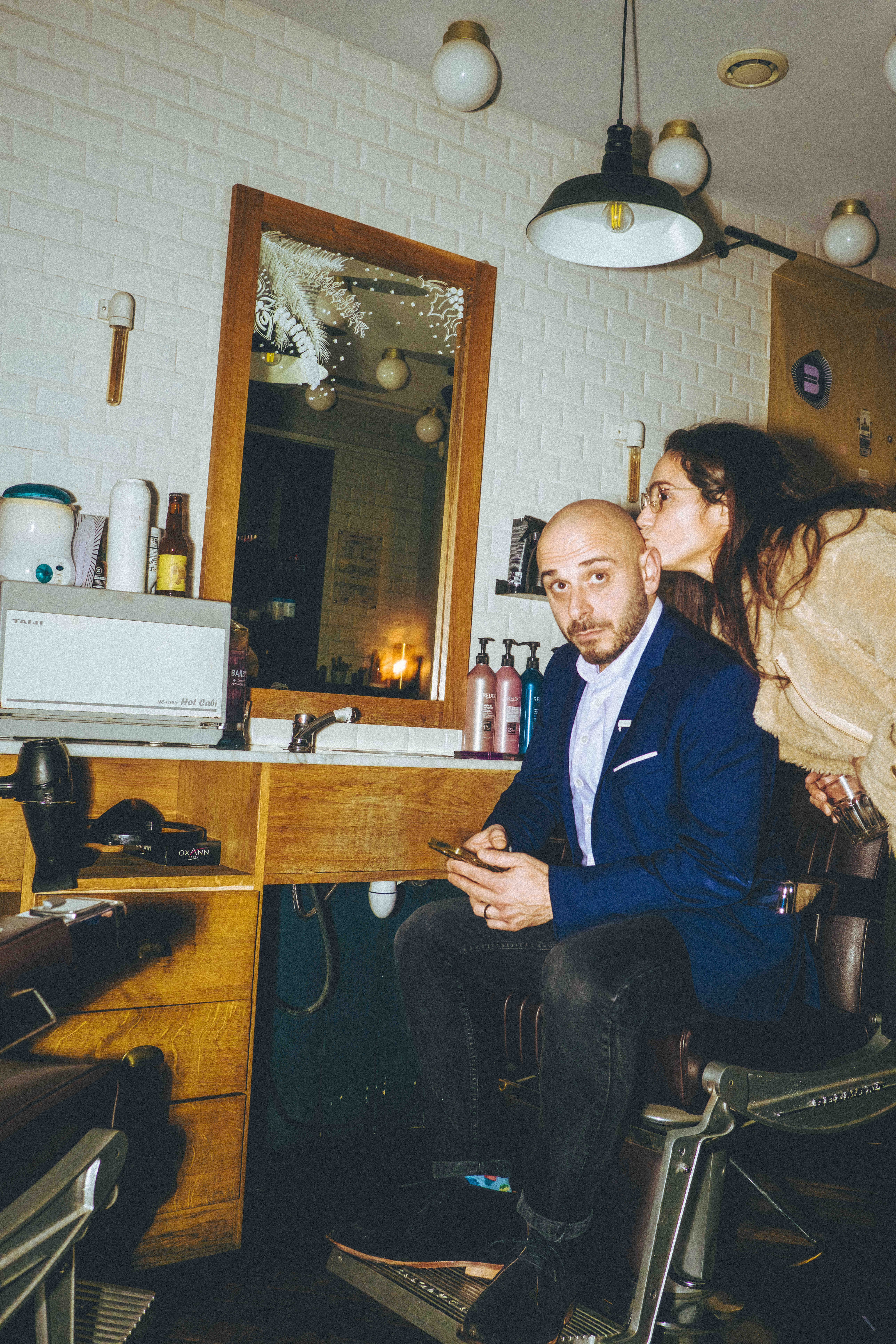 Coiffeur en veste bleue en consultation avec une cliente dans un salon ECLA Group