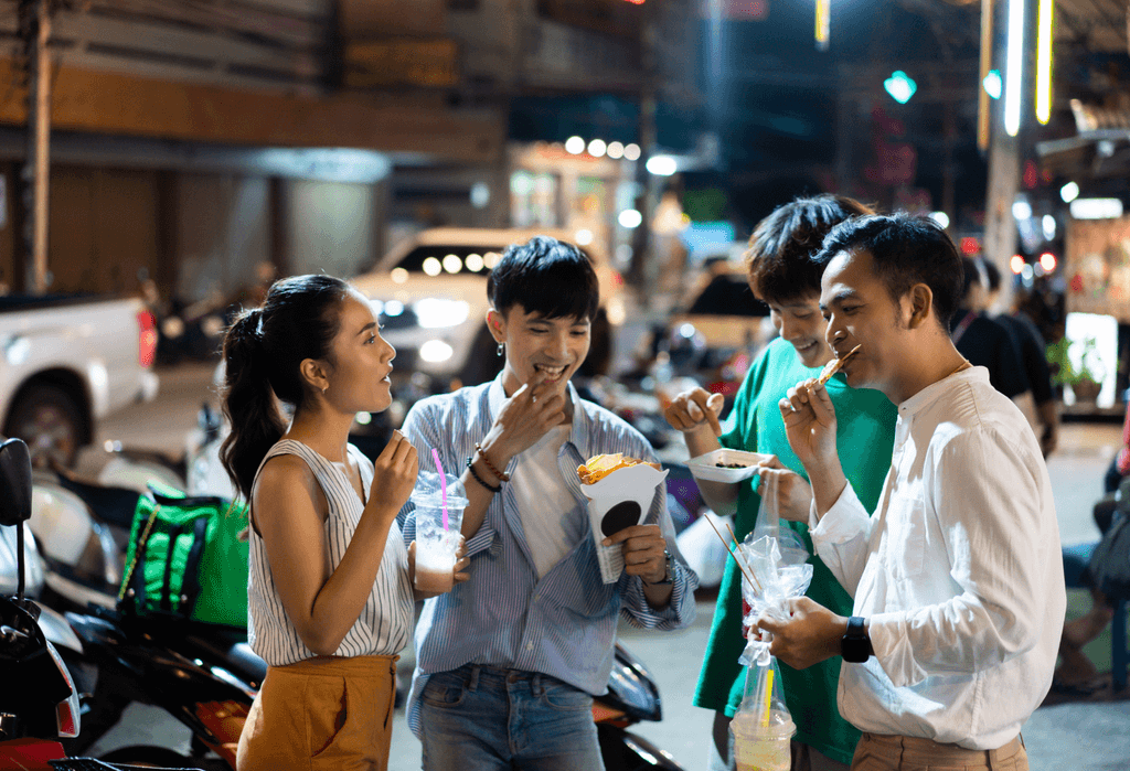 group of friends eating at a street market