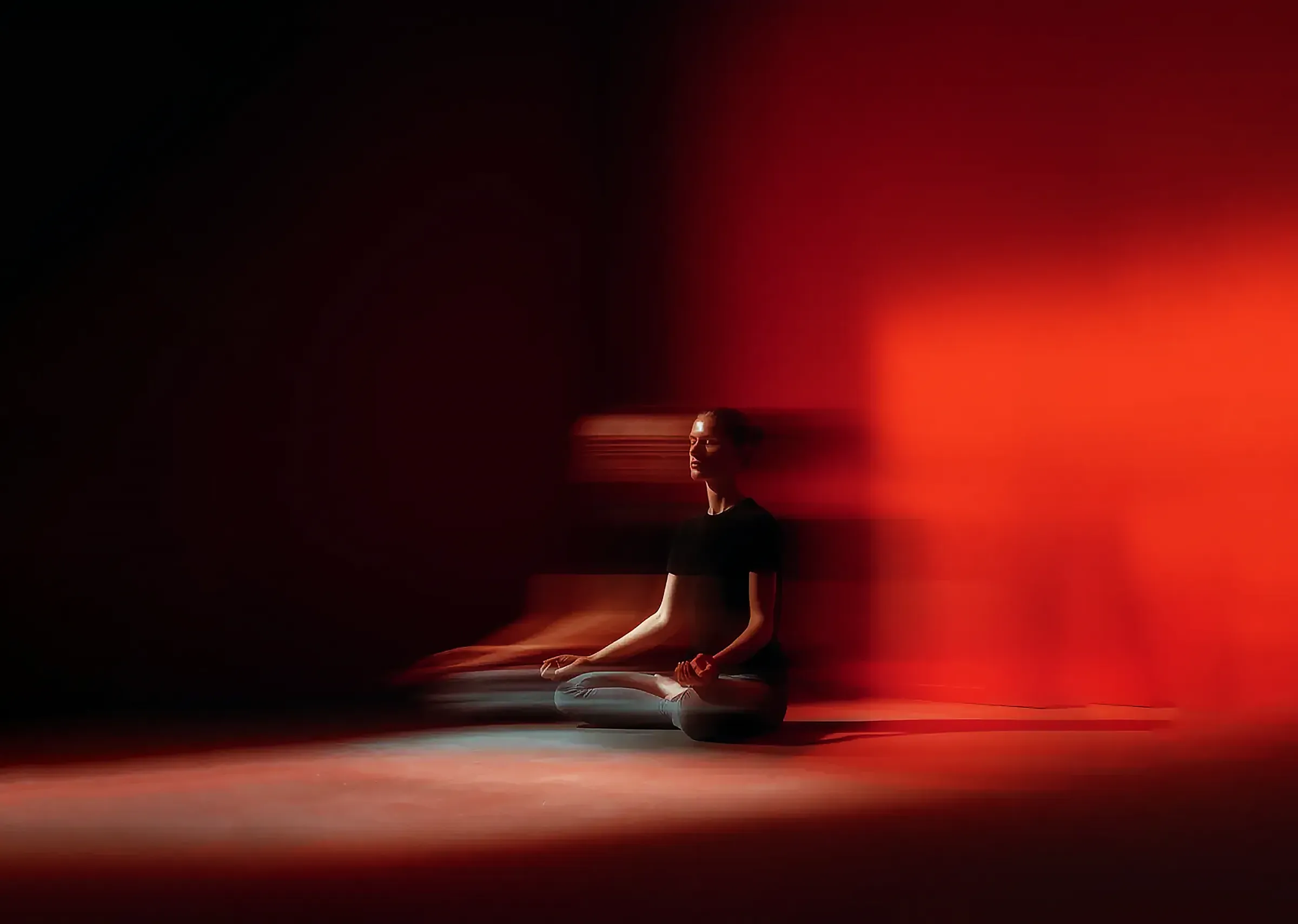 A woman doing yoga meditation in red light