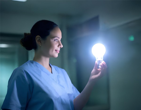 radiation therapist holding a lightbulb and looking inspired