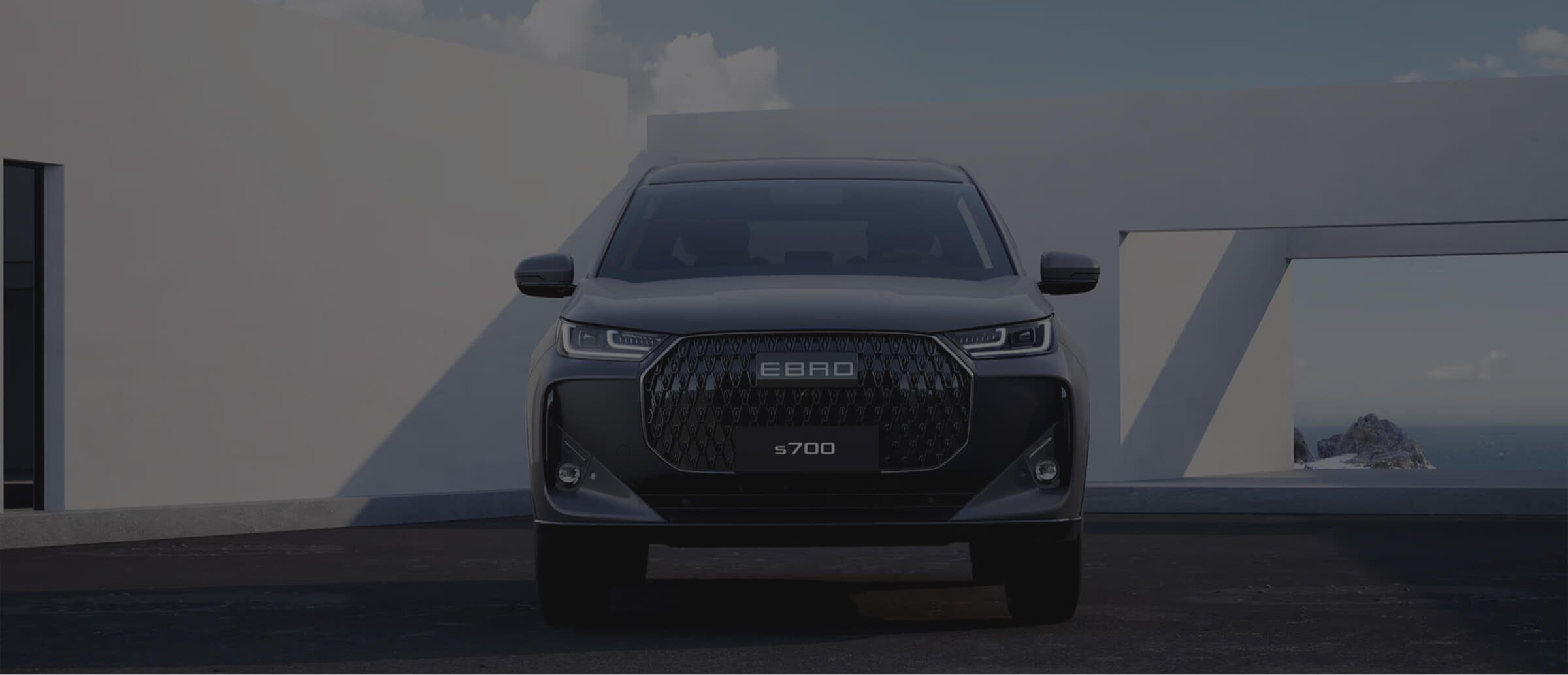 "Un SUV Citroën azul circulando por una calle urbana con fachadas de tiendas y edificios antiguos en un entorno soleado."