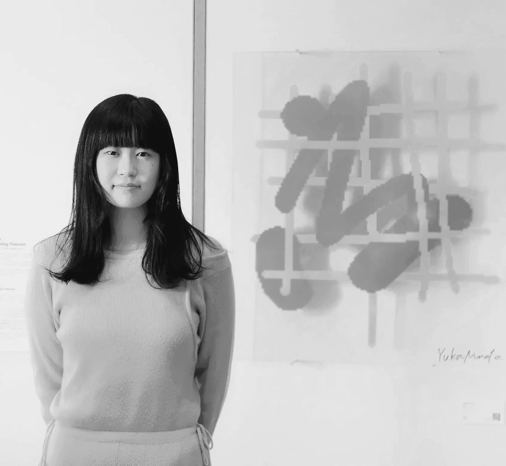 A woman observes framed black-and-white photographs in warm golden light