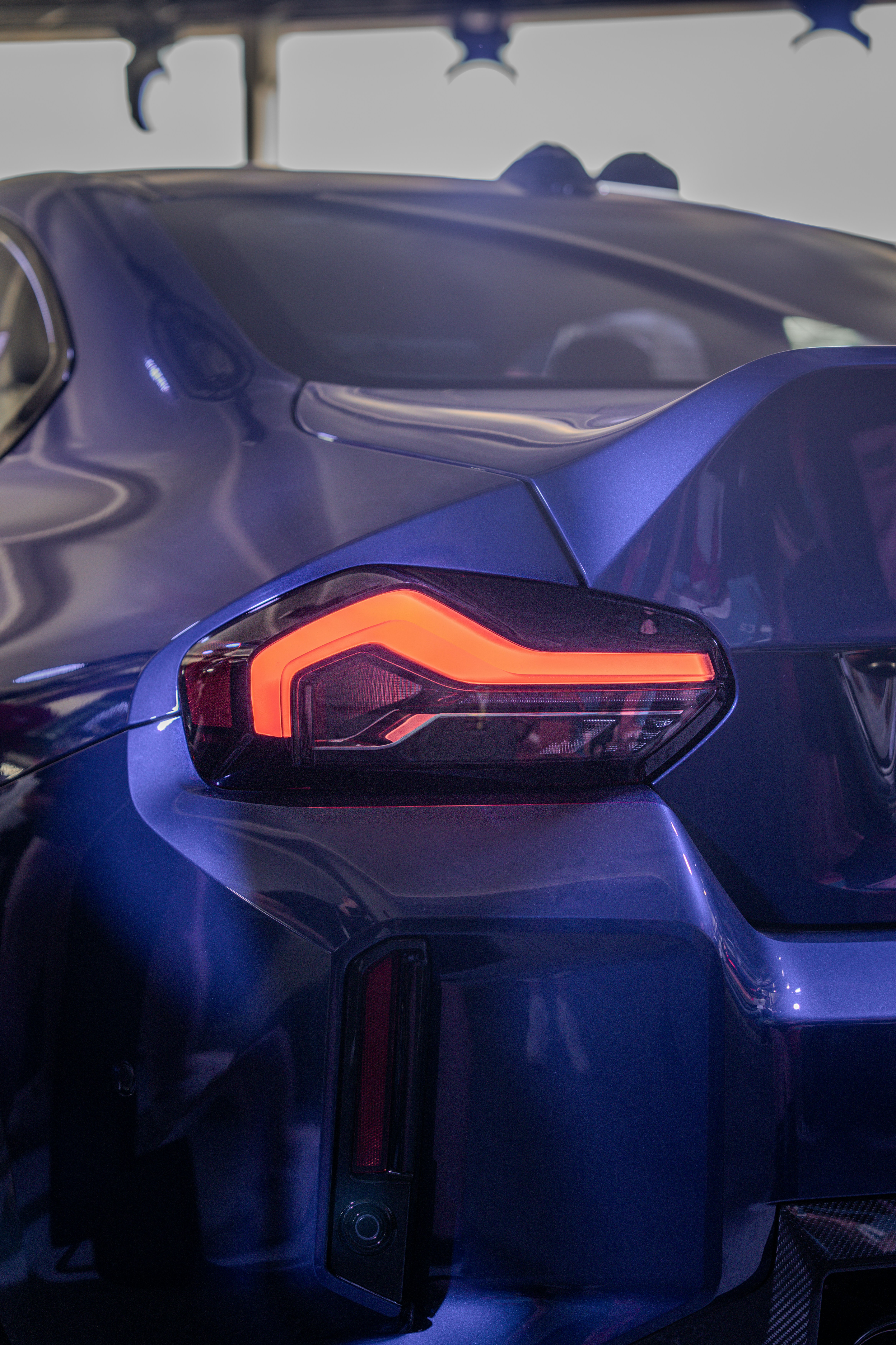 Blue car's tail light illuminated brightly.