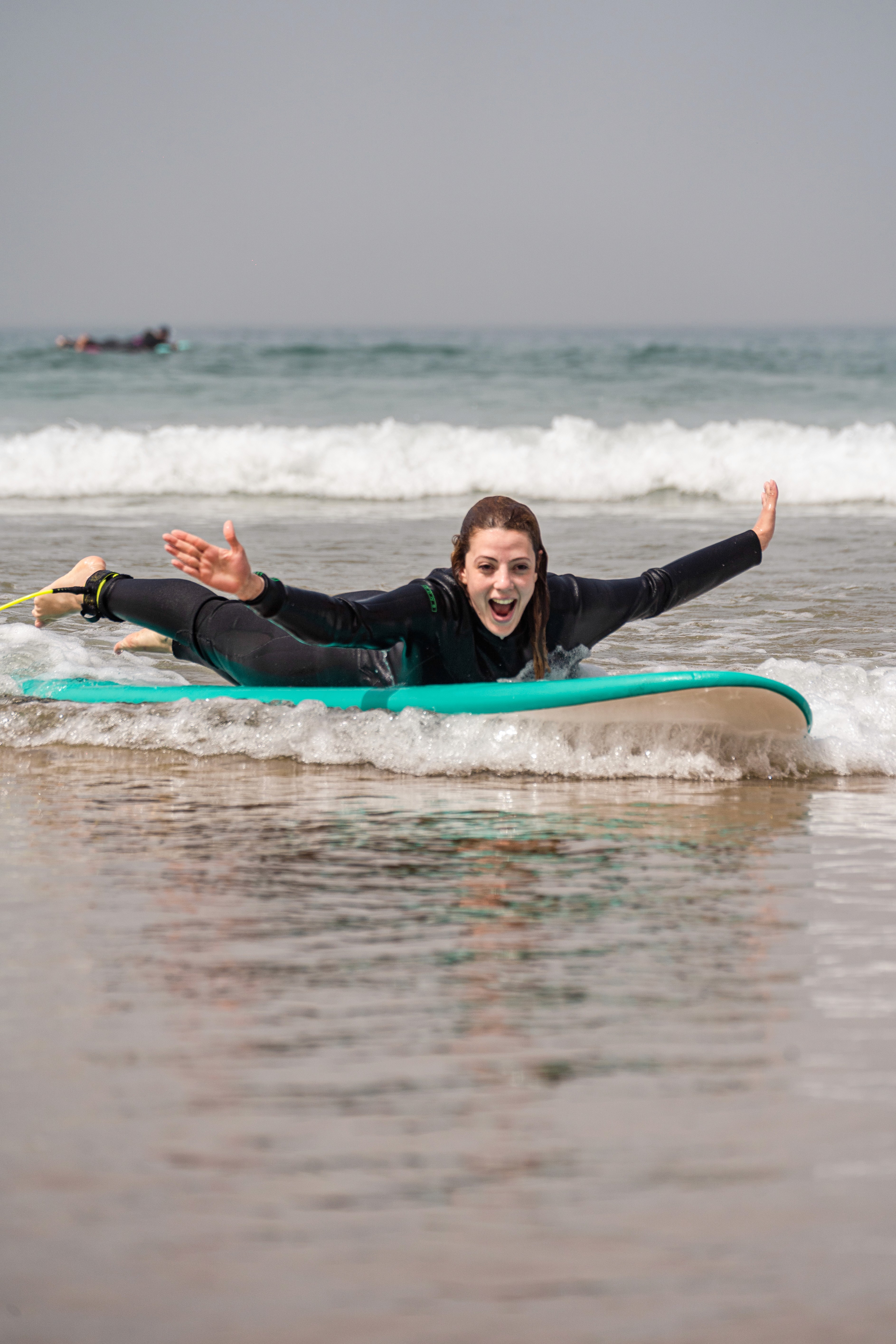 a group of people carrying surfboards on top of a beach