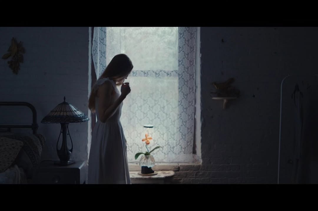Flora Piper standing beside a window in Bloom