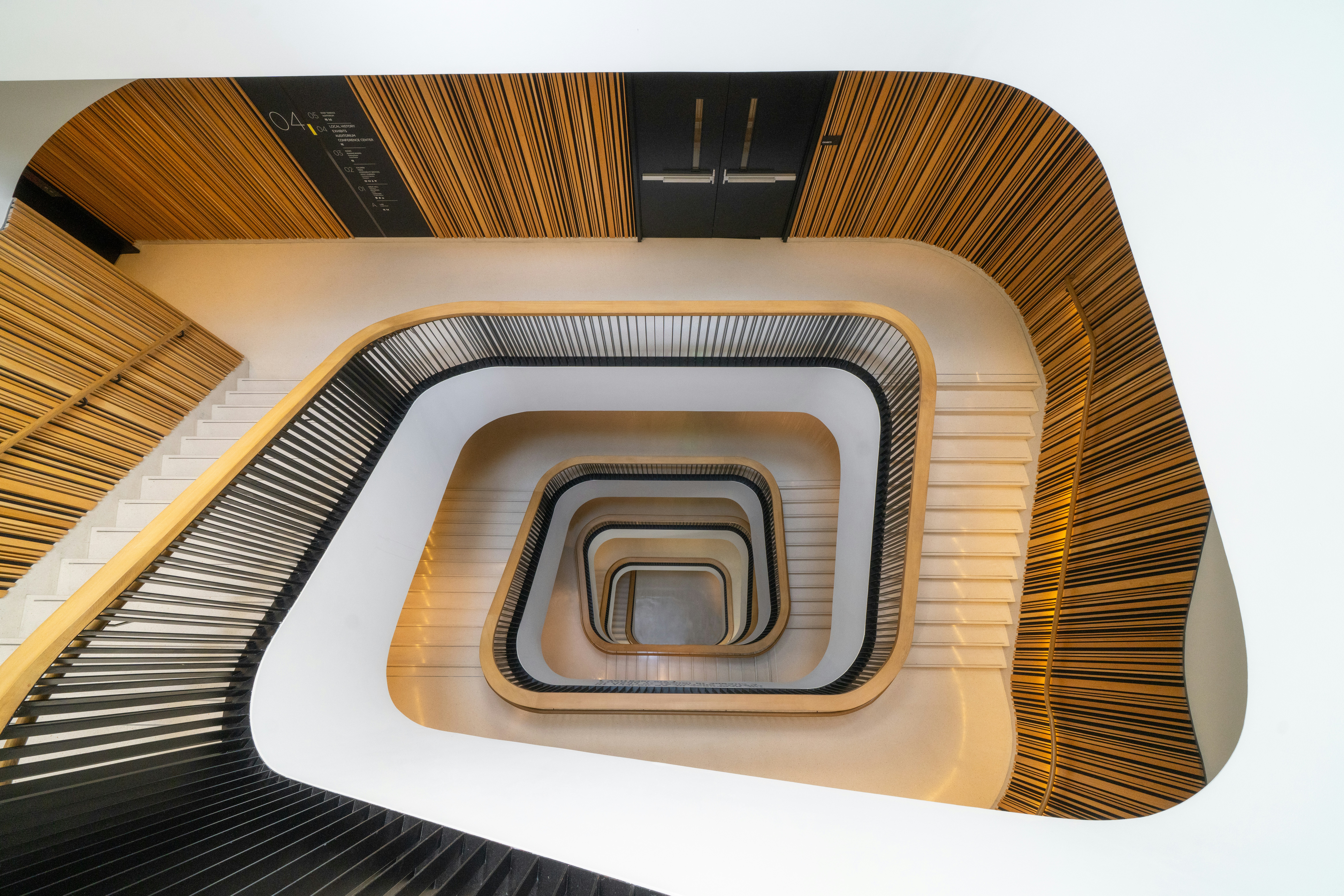Modern spiral staircase with wooden accents and white walls