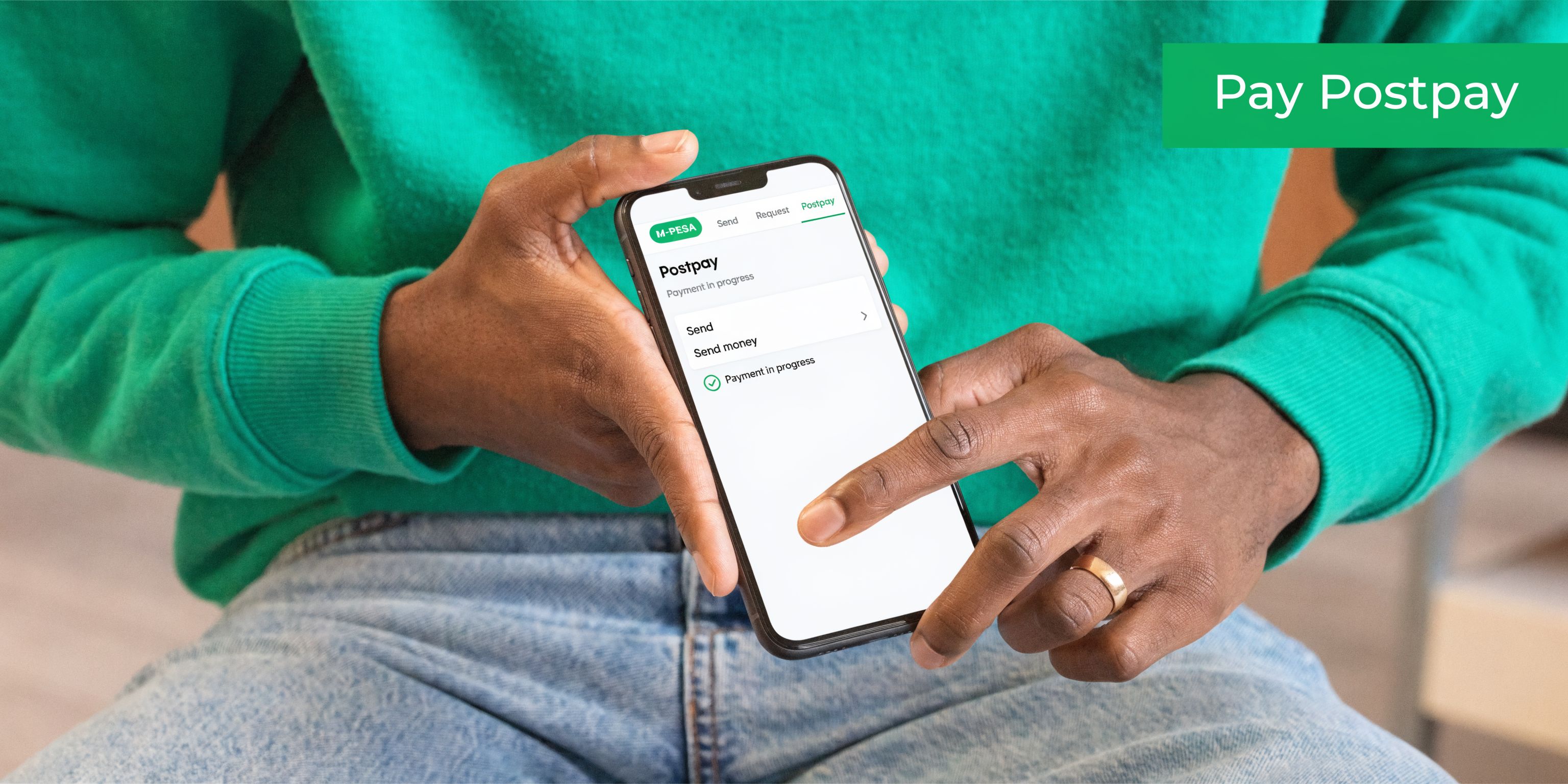 A person using an M-PESA mobile app on a smartphone to make a Postpay payment transaction.