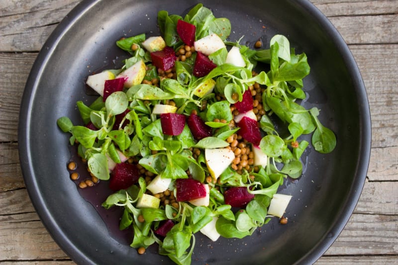 salad with beets in it on black plate on wood table