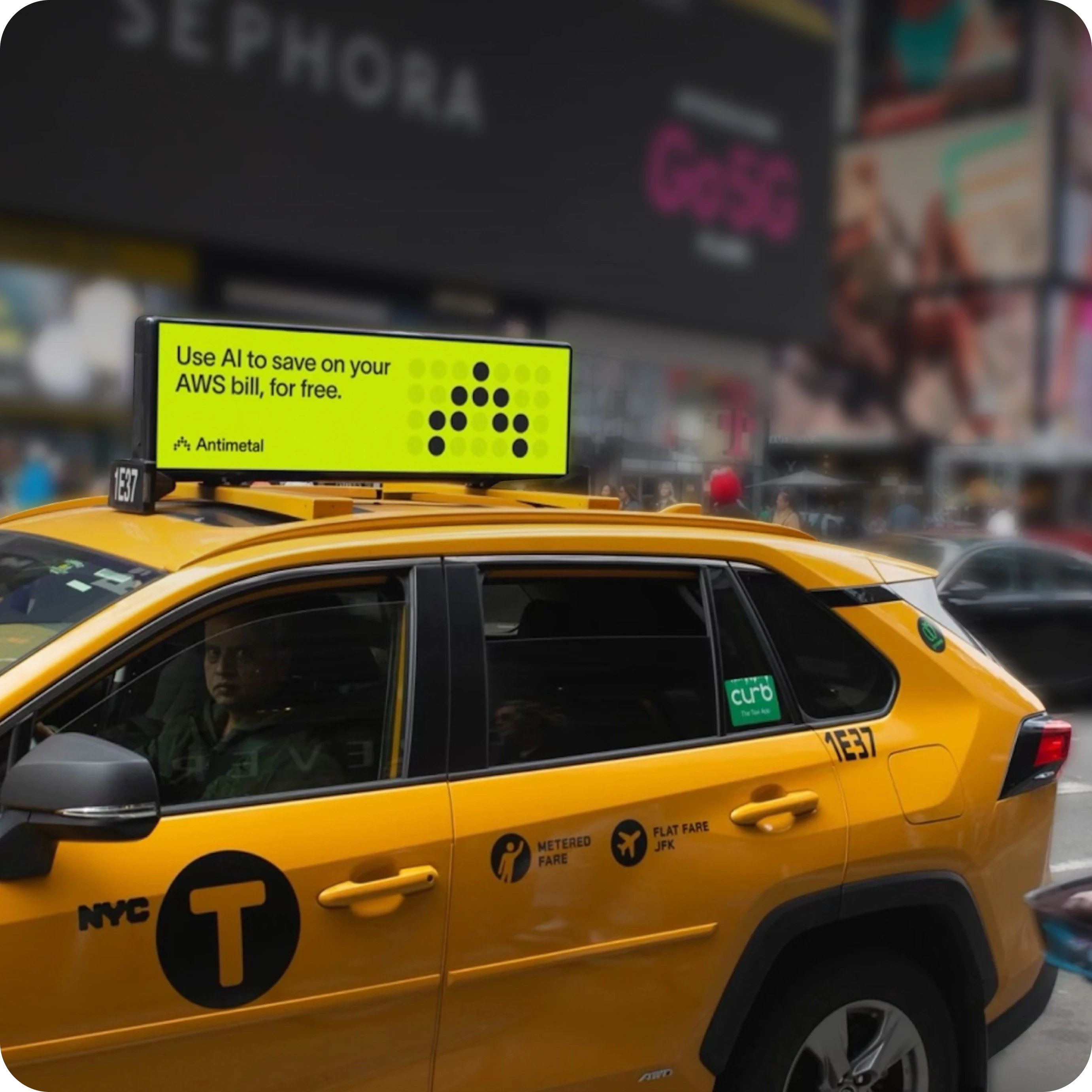 Yellow NYC taxi featuring an Antimetal advertisement on its roof. The bright neon green ad displays the message, "Use AI to save on your AWS bill, for free," alongside the Antimetal logo. The taxi is in a bustling urban environment with blurred signage and storefronts in the background.