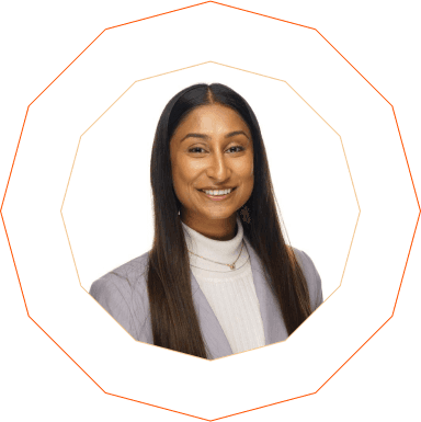 Portrait of Anmol Patel, Social Media & Insights Manager at TCS. She is smiling and wearing a light lilac blazer over a white turtleneck top, with long straight hair and a white background, framed by a geometric orange outline.