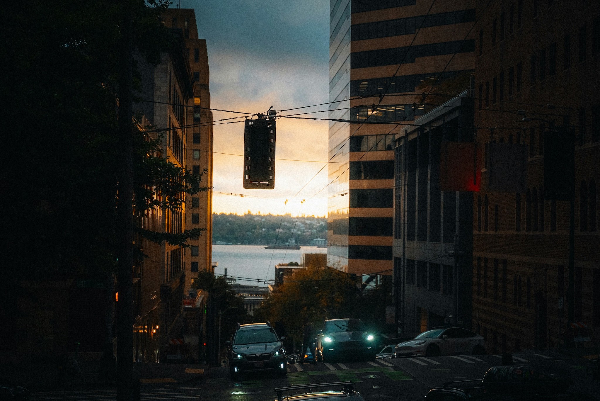 City street with cars at sunset overlooking water