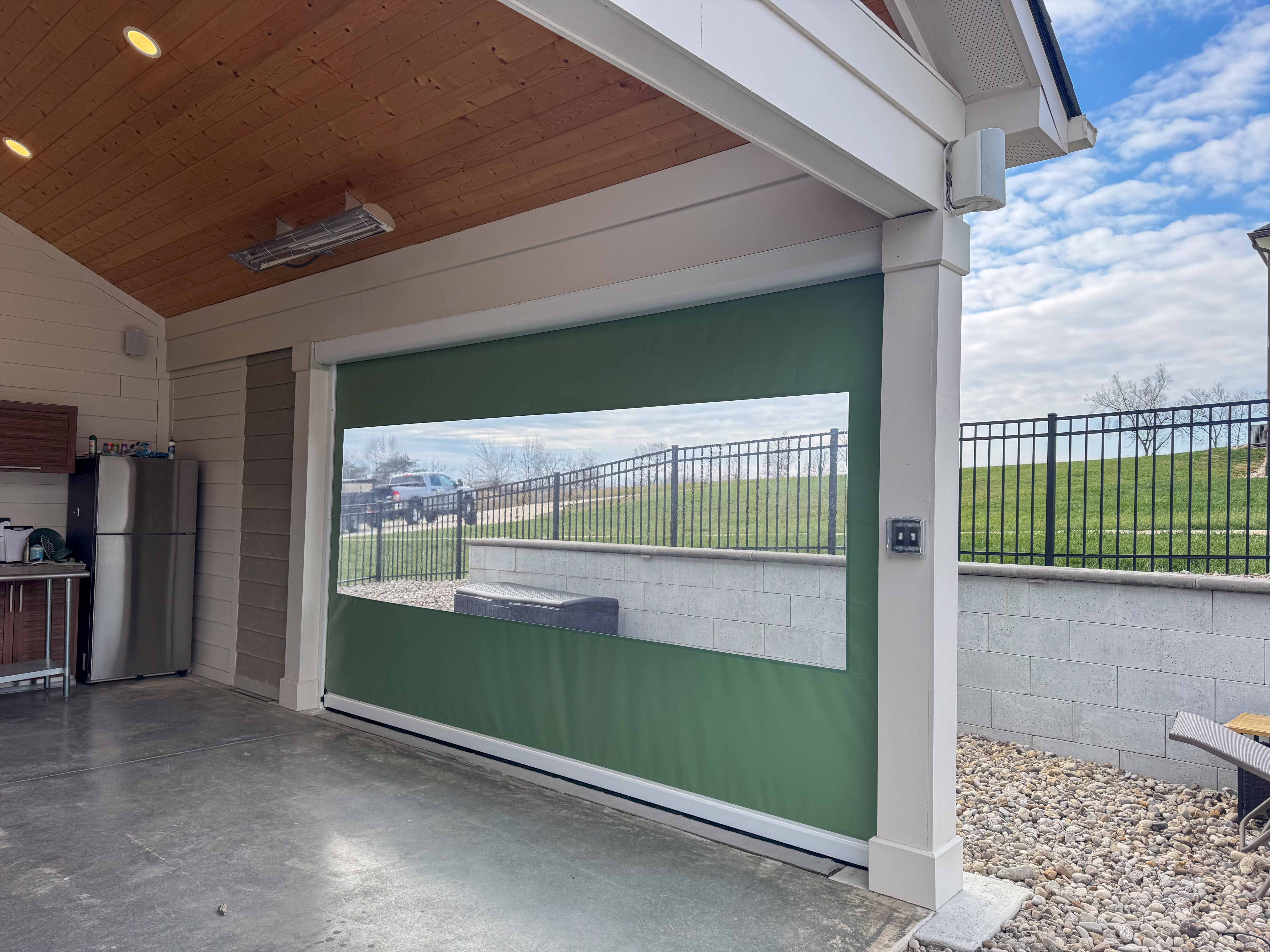 Retractable patio screen with wood ceiling and concrete floor