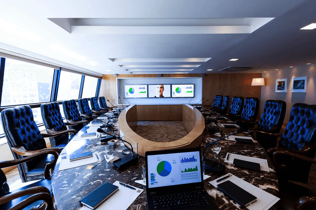 Boardroom with leather chairs and presentation screens.