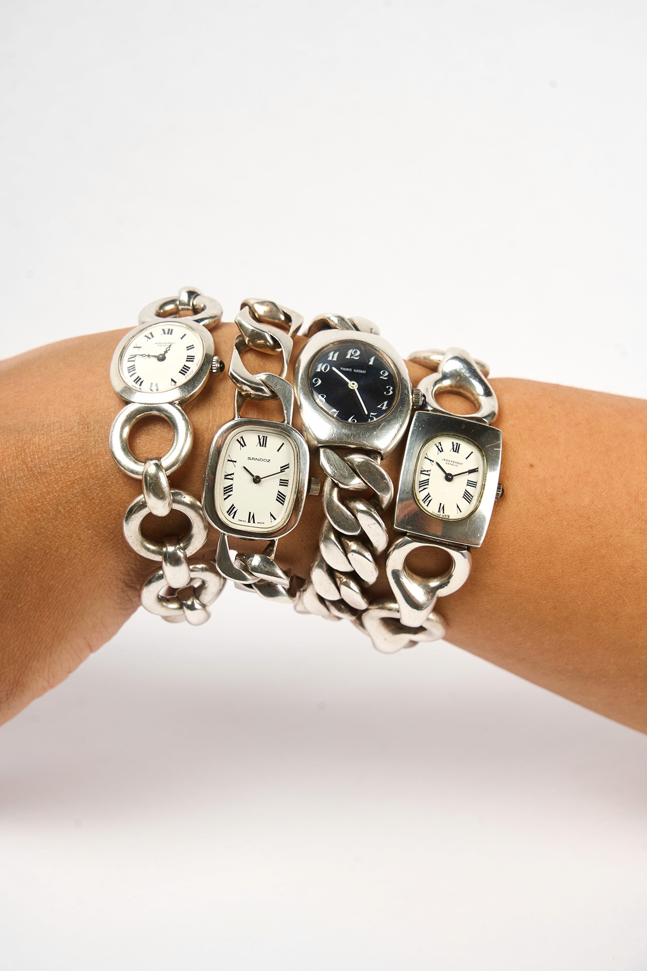 Une femme porte une sélection de montre vintage en argent autour de son poignet