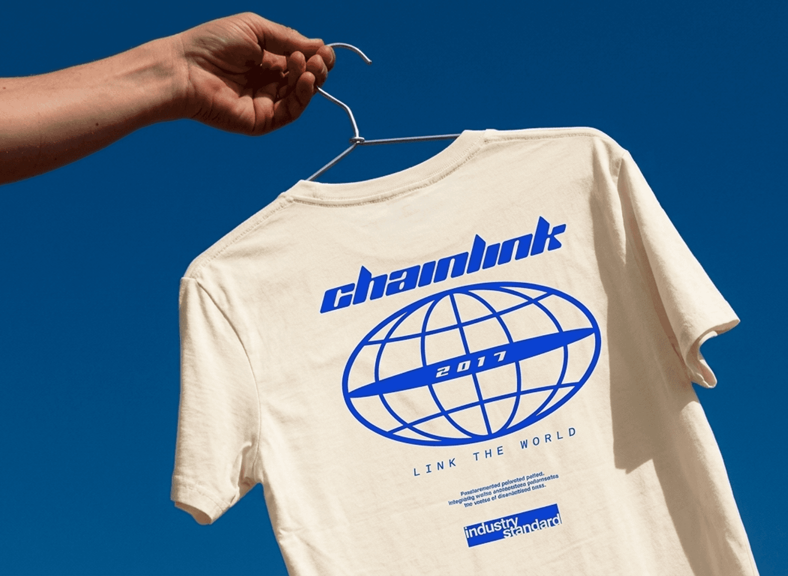 man wearing grey t-shirt standing in front of man sitting on chair