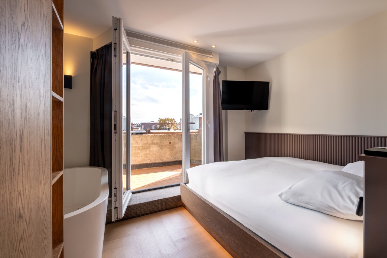 Luxe suite in Hotel Four Stories met open balkondeur en uitzicht in Scheveningen